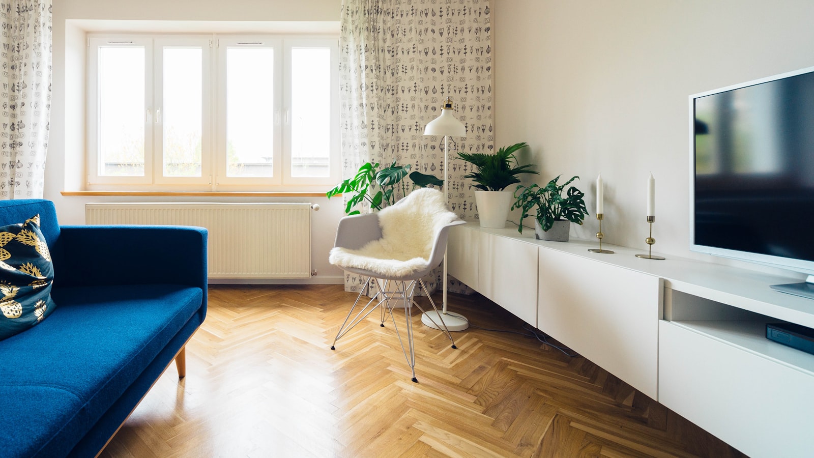 A neutral patterned area rug anchoring a living room seating arrangement on a wood floor
