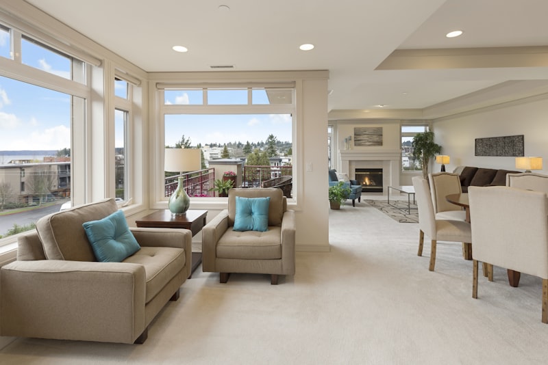 A compact living room with a slim sofa, a round coffee table, and a large mirror reflecting daylight