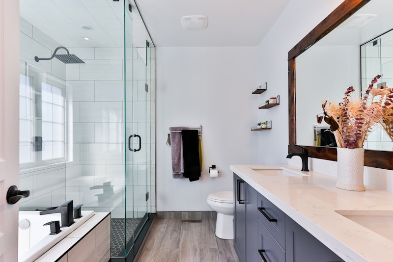 A compact modern bathroom with a round mirror, wall sconce, and floating vanity